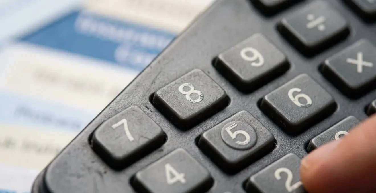 Gros plan sur une calculatrice moderne avec documents d'assurance flous en arrière-plan