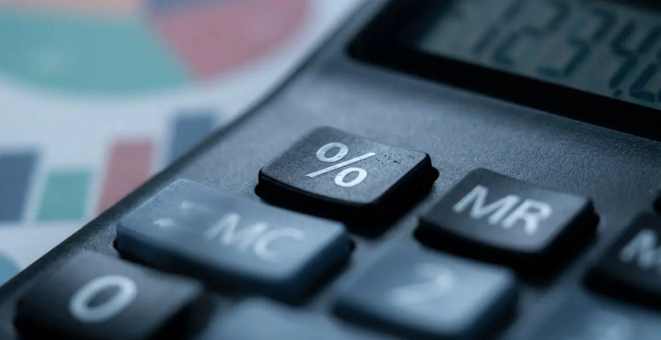 Vue macro d'une calculatrice avec des graphiques de pourcentages flous en arrière-plan